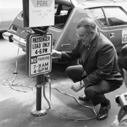 [Seattle City Light Superintendent Gordon Vickery demonstrates  Electro Park charging station recharging the battery of a prototype electric car.]